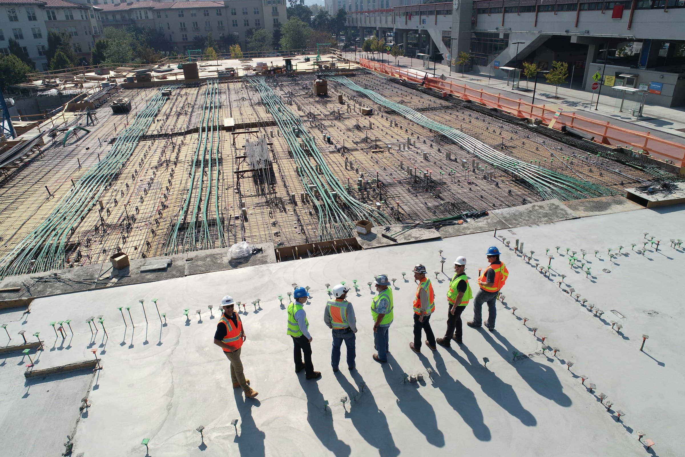 Commercial concrete construction crew on a poured deck with rebar